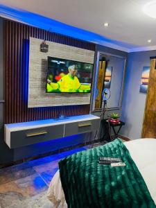 uma sala de estar com uma televisão na parede em Executive Galaxy Guest House Nkowankowa 