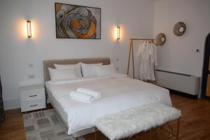 1 dormitorio con 1 cama blanca y 2 toallas en Rokebea Luxury en Brasov