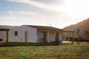 uma pequena casa branca no meio de um campo em PARADAISE SUITES SEA VIEW SARDINIA, Bedda Ista em Castelsardo
