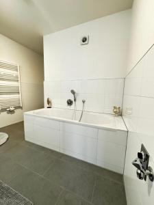 eine weiße Badewanne im weißen Badezimmer in der Unterkunft Haus Gitta II in Luckenwalde