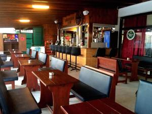 a restaurant with wooden tables and chairs and a bar at Carina Hotel Apartments in Ayia Napa