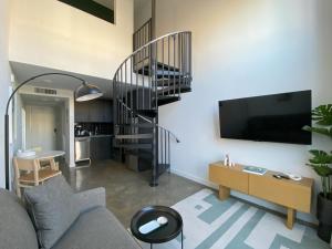 a living room with a staircase and a tv at Mint House Birmingham - Downtown in Birmingham
