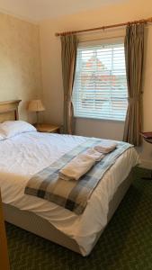 een slaapkamer met een bed met twee handdoeken erop bij The Bell Hotel in Burgh le Marsh