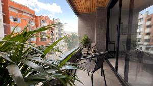 uma varanda com duas cadeiras e algumas plantas em Luxe Apt in Laureles by Hoost em Medellín
