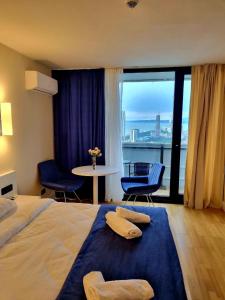 una camera d'albergo con letto e tavolo con sedie di Orbi City Apartment Sea View a Batumi