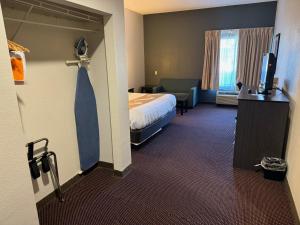 a hotel room with a bed and a tie at Quality Inn & Suites Hattiesburg North in Hattiesburg +14 photos