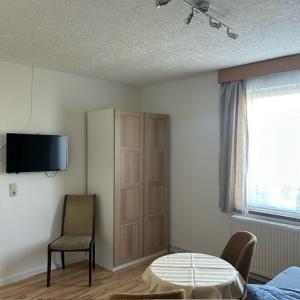 PruchtenにあるFerienpark Buntspecht Apartment 1のベッドとテーブルと椅子のある部屋 +5枚の写真