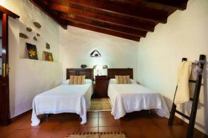 a room with two beds with white sheets on them at 5 bedrooms chalet with wifi at Firgas in Firgas