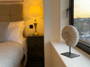 a bedroom with a bed and a table with a fan at Elegant One Bedroom Apartment in Swindon