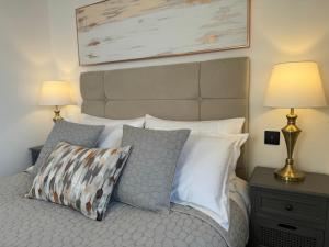een slaapkamer met een bed met kussens en een foto aan de muur bij Elegant One Bedroom Apartment in Swindon
