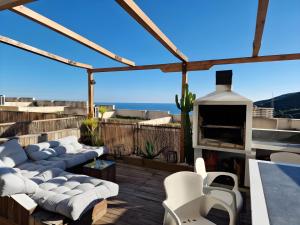 un patio con muebles blancos y vistas al océano. en Peñiscola - Casa Mirador mit Gemeinschaftspool en Castellón de la Plana