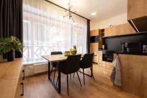 デマノブスカ・ドリーナにあるApartmán naCHALETY JASNÁのテーブルと椅子のあるキッチンとダイニングルーム +5枚の写真