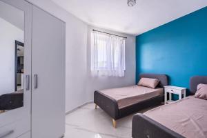 a bedroom with two beds and a window at Sunset Bliss Luxury Apartment in St. Paul's Bay