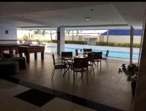 a dining room with a table and chairs and a pool at AP 306 flat beira mar praia Tambaú in João Pessoa +17 photos