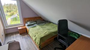 a bedroom with a bed and a desk and a window at Ja wolę w Ostrykole in Prostki