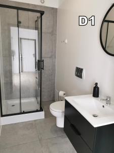 a bathroom with a shower and a toilet and a sink at DM DOMKI Kościelna 54 in Mielno