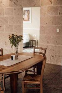 una mesa de madera con sillas y un jarrón con flores. en Glenberrie Place ECO Retreat, en Kangarilla