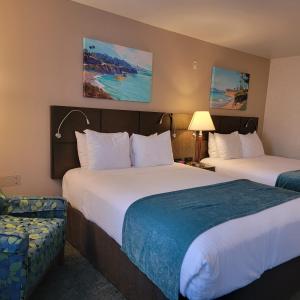 um quarto de hotel com duas camas e uma cadeira em Old Town Inn em San Diego