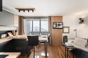 una cucina e un soggiorno con tavolo e sedie di Résidence OrsiÈre - 2 Pièces pour 4 Personnes 074 a Val Thorens