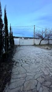 a stone walkway with a fence and a stone ground at Просторный дом в элитном районе Тбилиси in Okrokana