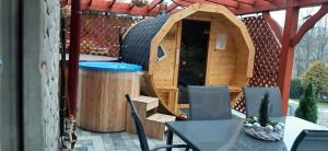 a dog house on a patio with a table and chairs at Agroturystyka U Misia in Niedźwiedź