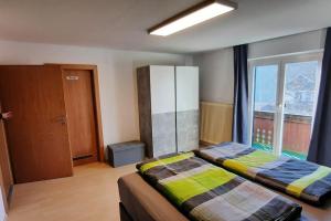 a bedroom with two beds and a large window at Ferienwohnung in Weyregg am Attersee in Weyregg