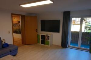 a living room with a couch and a flat screen tv at Ferienwohnung in Weyregg am Attersee in Weyregg