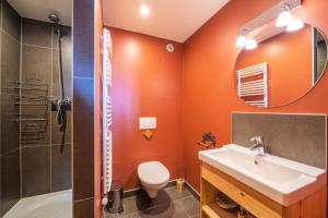 a bathroom with orange walls and a sink and a shower at Chalet Dauphin - Chalets pour 15 Personnes 264 in LʼHuez