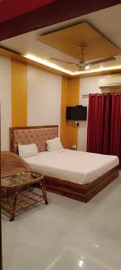 a bedroom with a large bed and a table at Hotel Shiv Ganga in Rishīkesh