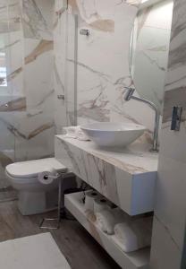 uma casa de banho branca com um lavatório e um WC em Flats Asa Norte CLN 110 by CentoEdez em Brasília