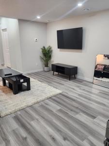 a living room with a flat screen tv on a wall at Trendy 2-Bed Oasis Awaits! in Calgary