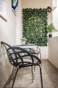 une table et une chaise devant un mur vert dans l'établissement Lefkes Studios, à Naxos Chora