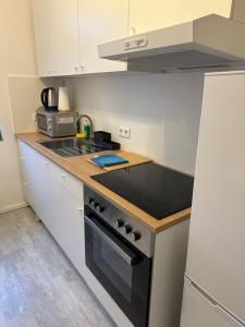 a kitchen with a stove and a sink at Place to sleep - Kassel: Direkt an der Uni in Kassel