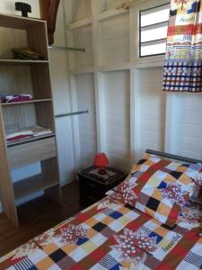 1 dormitorio con 1 cama con colcha colorida en Villa des fleurs, en Pointe-Noire