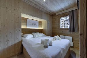 een slaapkamer met 2 bedden in een houten hut bij Residence Telemark - 2 Pièces pour 4 Personnes 104 in Val dʼIsère