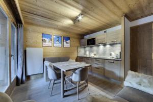 een keuken met een tafel en stoelen en een koelkast bij Residence Telemark - 2 Pièces pour 4 Personnes 104 in Val dʼIsère