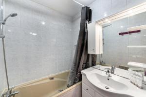La salle de bains est pourvue d'un lavabo, d'une douche et d'une baignoire. dans l'établissement Résidence Le Serac - Studio pour 4 Personnes 294, à Val Thorens
