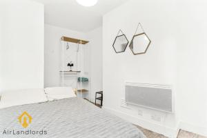 1 dormitorio blanco con 1 cama y TV en Fab 3bed 3bath Flat Kings Cross, en Londres