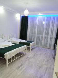 1 dormitorio con 2 camas y lámpara de araña en Geno Guest House en Kvariati