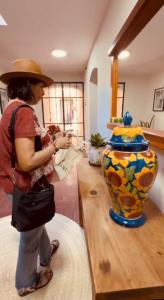 Una mujer con sombrero mirando un jarrón en Casa Nabani Oaxaca, en Oaxaca City