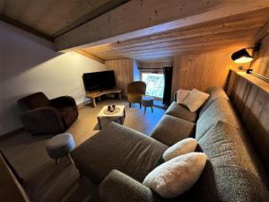 ein Wohnzimmer mit einem Sofa und einem TV in der Unterkunft Chalet Aster - 4 Pièces pour 6 Personnes 444 in Saint-Marcel