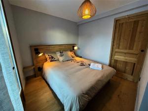 a bedroom with a large bed and a wooden door at Chalet Aster - 4 Pièces pour 6 Personnes 444 in Saint-Marcel