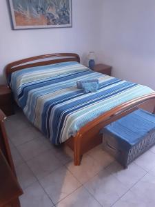 a bed with a striped blanket on top of it at Appartamento al mare in Porto Santo Stefano