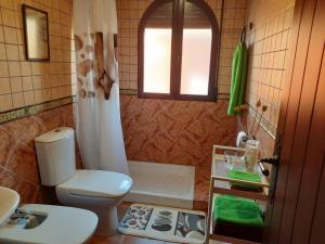 a bathroom with a toilet and a sink and a tub at Villatrajín in Otura