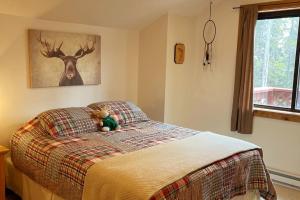 um urso de peluche sentado numa cama num quarto em Shady Pines- Cozy Mountain Retreat em Idaho Springs