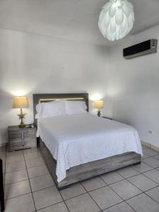 - une chambre avec un lit doté d'un couvre-lit blanc dans l'établissement Playa Apartments, à Salinas