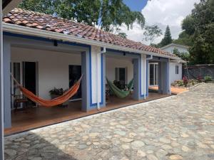 a house with hammocks on a patio at chez Yannick Hospedaje Los Amigos in Salento