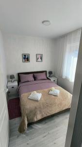 a bedroom with a large bed with two towels on it at Sunflower Apartmani in Soko Banja