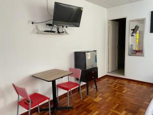 a room with a table and chairs and a television at Lima HOUSE MILANI in Lima