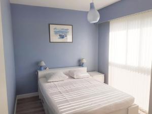 een slaapkamer met een bed met een blauwe muur bij 3 pièces 6 pers à 2 pas de la plage et du centre ville in Cavalaire-sur-Mer